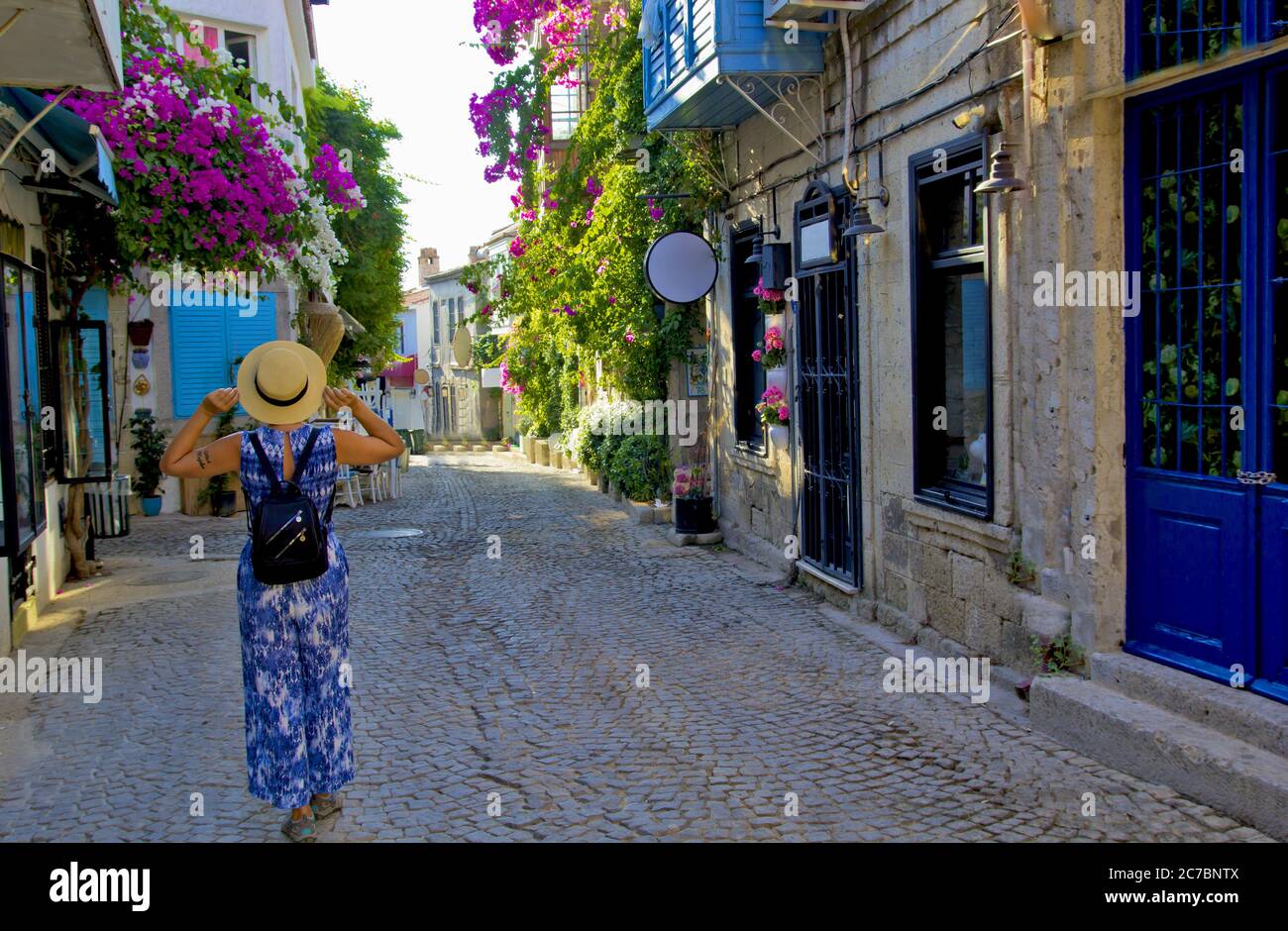 Giovane donna che cammina in una strada stretta ad Alacati, Cesme Turchia Foto Stock