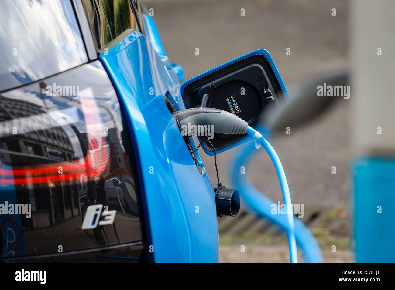 Essen, zona della Ruhr, Renania Settentrionale-Vestfalia, Germania - l'auto elettrica è a pagamento in un parcheggio con cavo di ricarica presso una stazione di ricarica. | Essen, Ruhr Foto Stock