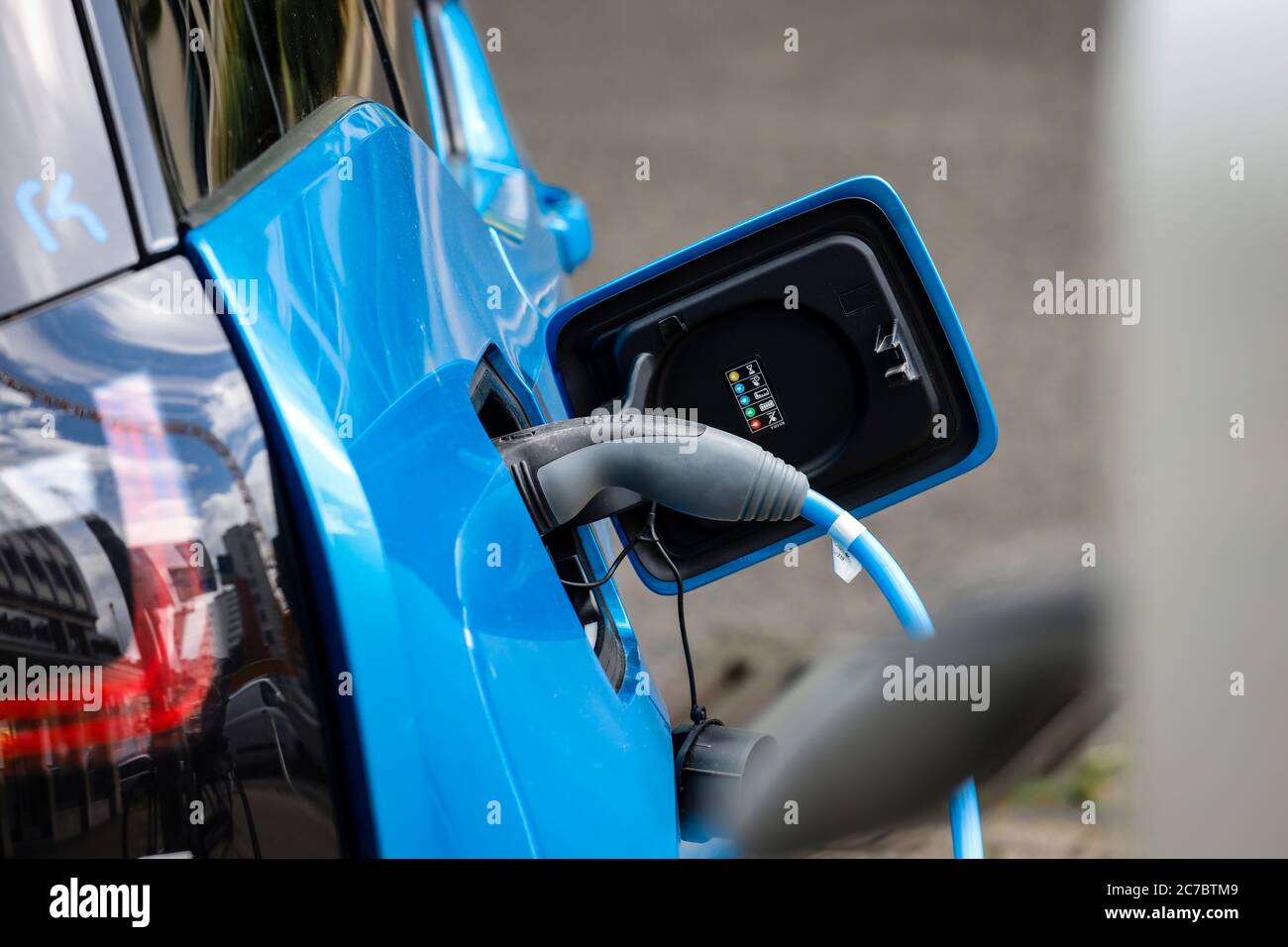 Essen, zona della Ruhr, Renania Settentrionale-Vestfalia, Germania - l'auto elettrica è a pagamento in un parcheggio con cavo di ricarica presso una stazione di ricarica. | Essen, Ruhr Foto Stock