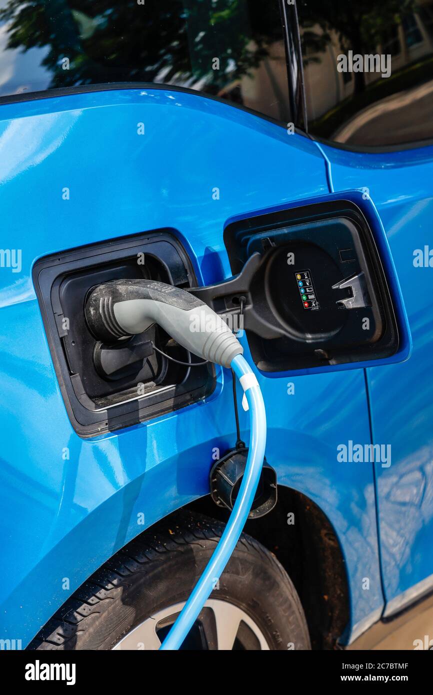 Essen, zona della Ruhr, Renania Settentrionale-Vestfalia, Germania - l'auto elettrica è a pagamento in un parcheggio con cavo di ricarica presso una stazione di ricarica. | Essen, Ruhr Foto Stock