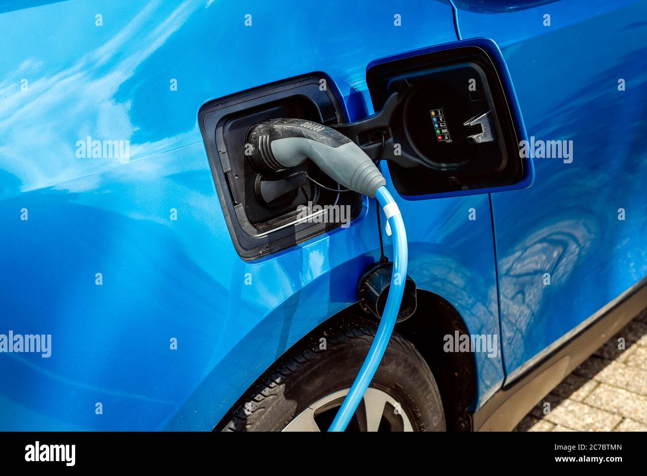 Essen, zona della Ruhr, Renania Settentrionale-Vestfalia, Germania - l'auto elettrica è a pagamento in un parcheggio con cavo di ricarica presso una stazione di ricarica. | Essen, Ruhr Foto Stock