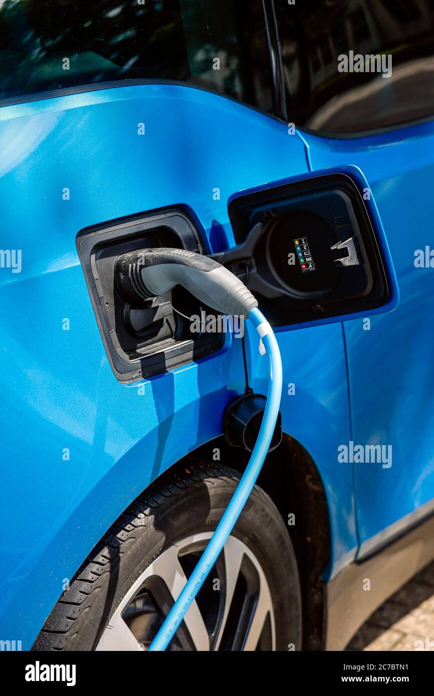 Essen, zona della Ruhr, Renania Settentrionale-Vestfalia, Germania - l'auto elettrica è a pagamento in un parcheggio con cavo di ricarica presso una stazione di ricarica. | Essen, Ruhr Foto Stock