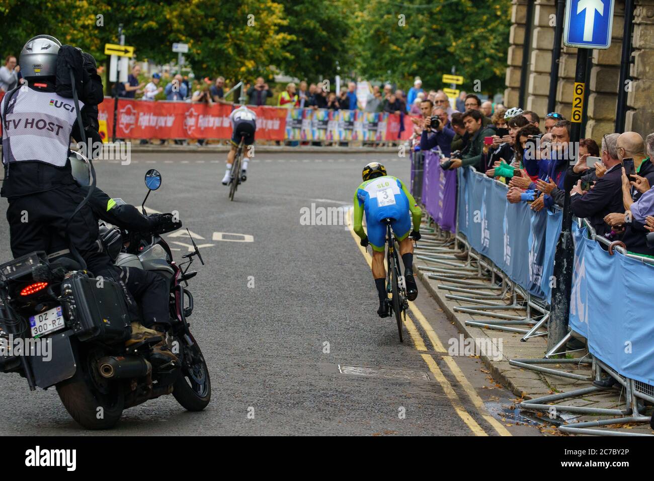 Primoz Roglic professionista ciclista essendo seguito da una moto con un cameraman TV lungo l'elite maschile tempo prova individuale, Harrogate, Regno Unito. Foto Stock