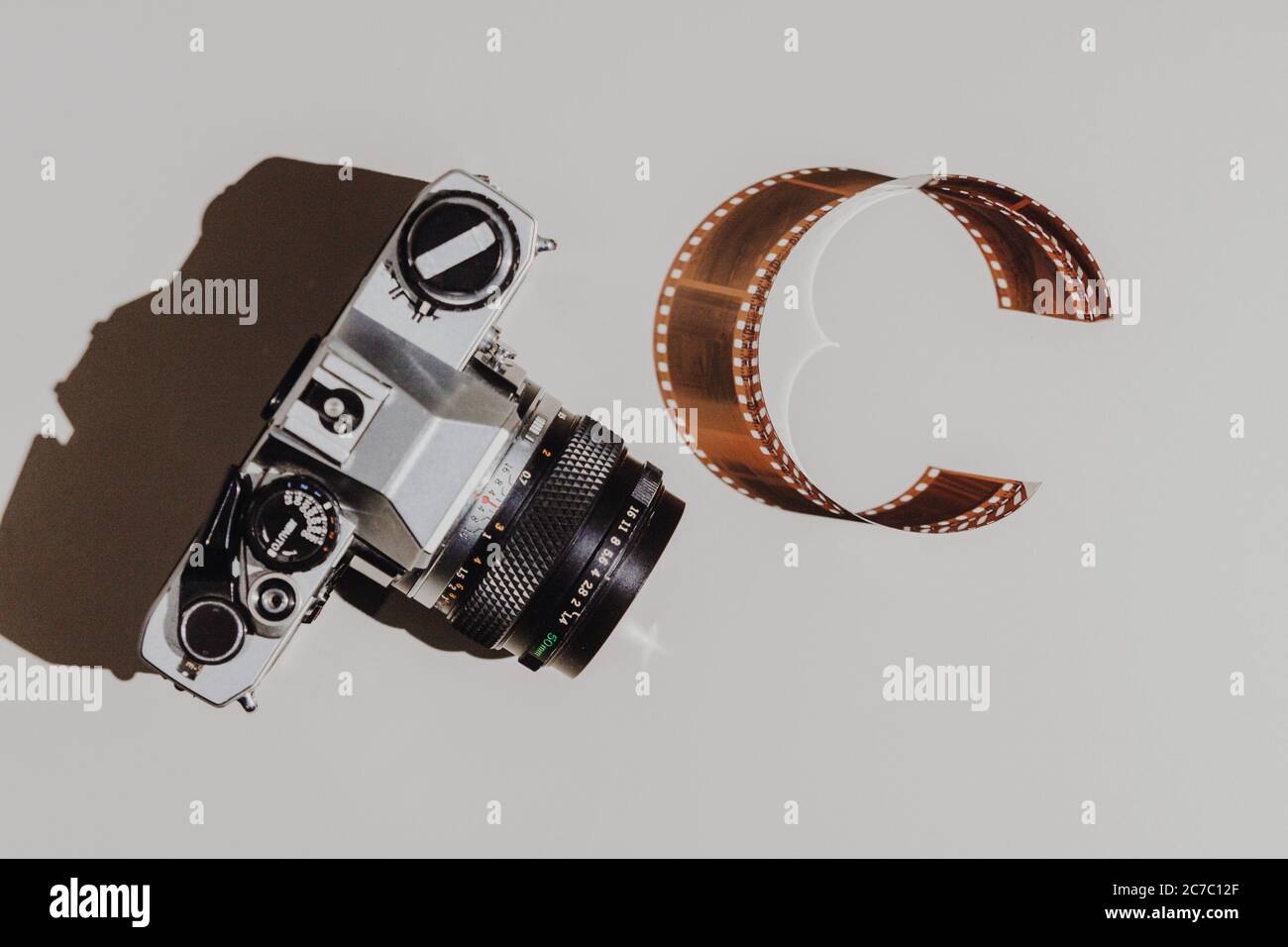 Set di posa geometrico piatto: Fotocamera vintage su sfondi chiari con pellicola da 35 mm. Vista dall'alto. Foto Stock