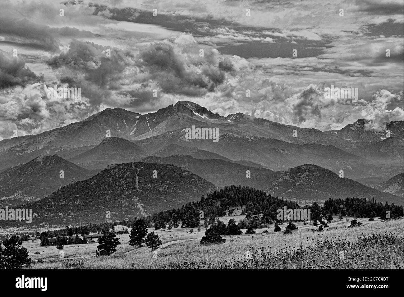 Paesaggio scala di grigi di montagne e campi con il nuvoloso cielo sullo sfondo Foto Stock