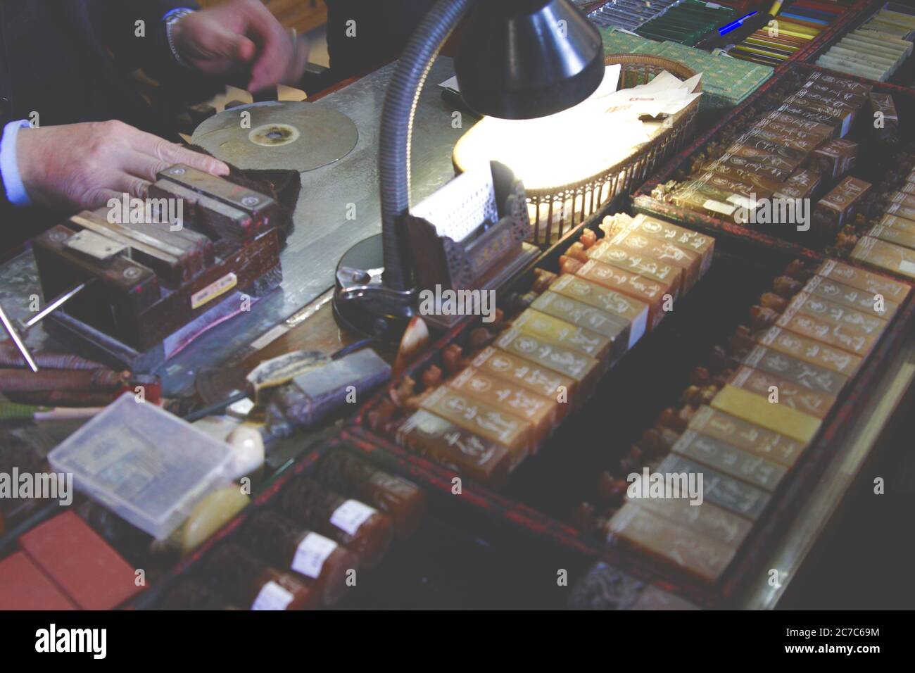 Foto ravvicinata di un maestro cinese che fa emblemi tradizionali gli emblemi organizzati nella scatola Foto Stock