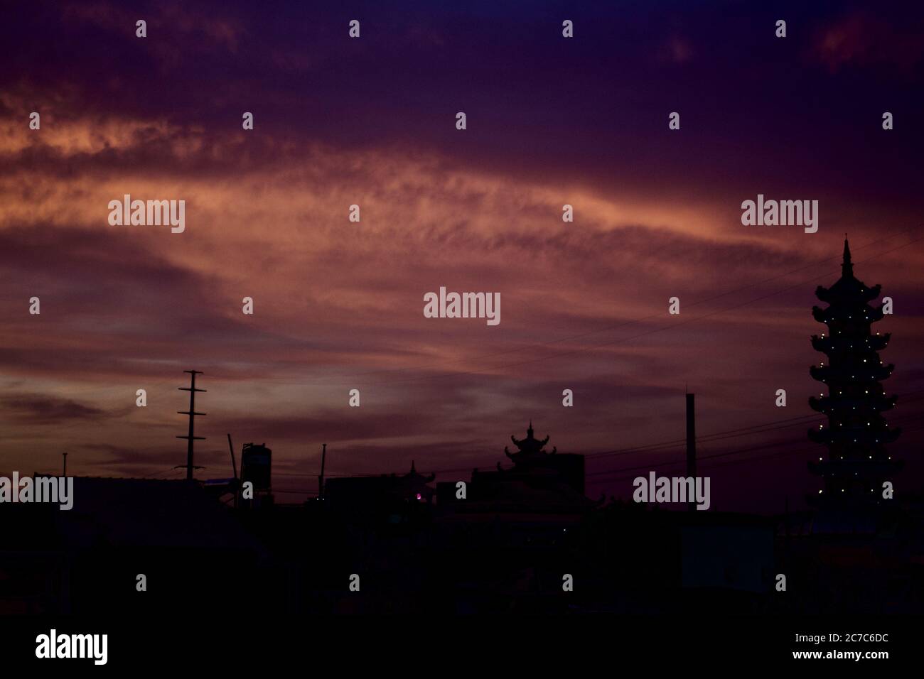 Ampio colpo di cielo durante il tramonto a ho Chi Minh City, Vietnam, dove è visibile una silhouette di pagoda Foto Stock