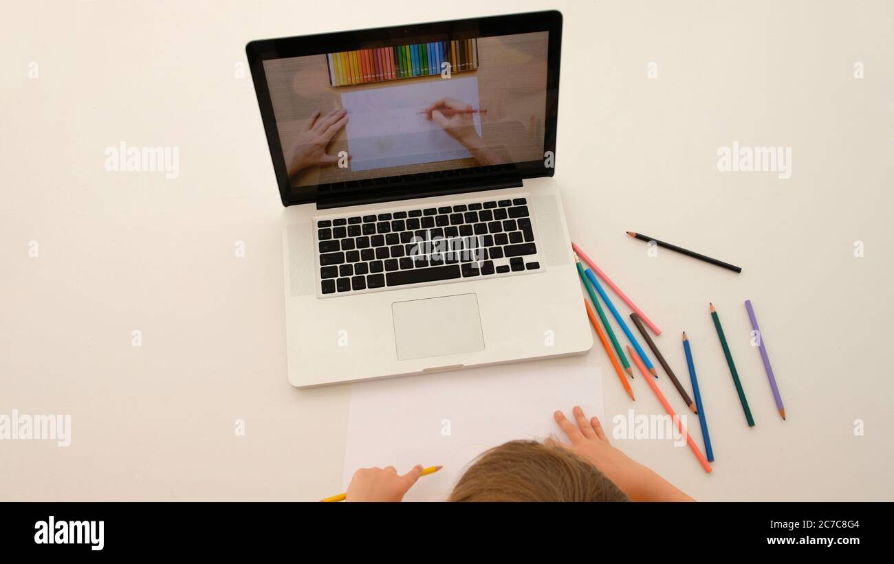 Il bambino impara a disegnare da un tutorial su un laptop Foto Stock