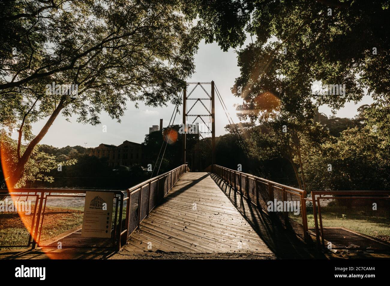 Ripresa orizzontale di un ponte sospeso su un fiume un parco Foto Stock