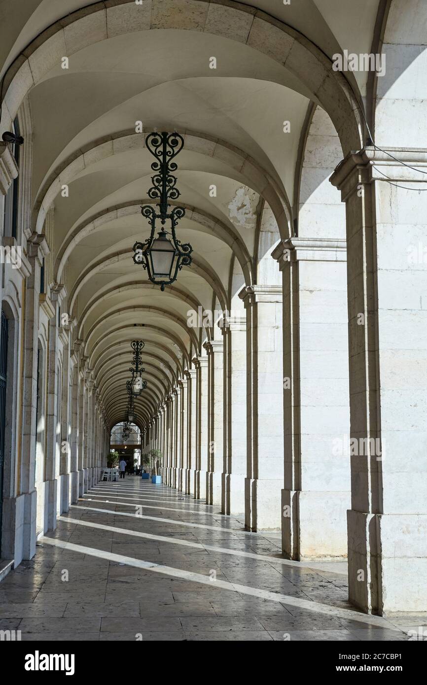 Colonne lungo la piazza commerciale 'Praca de Commercio' di Lisbona all'alba Foto Stock