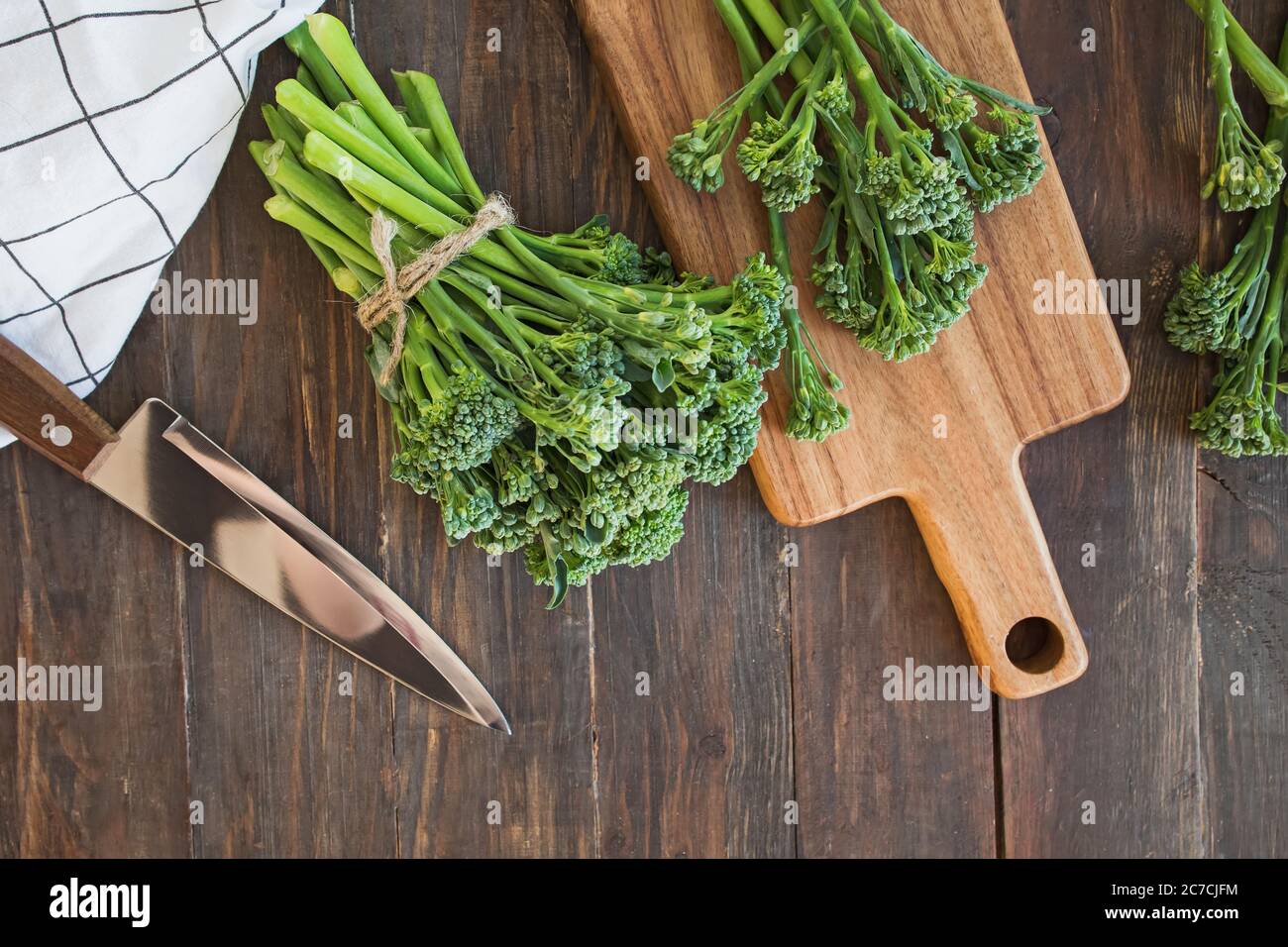 Verdure crude di broccolini verdi su tavola di legno. Foto Stock