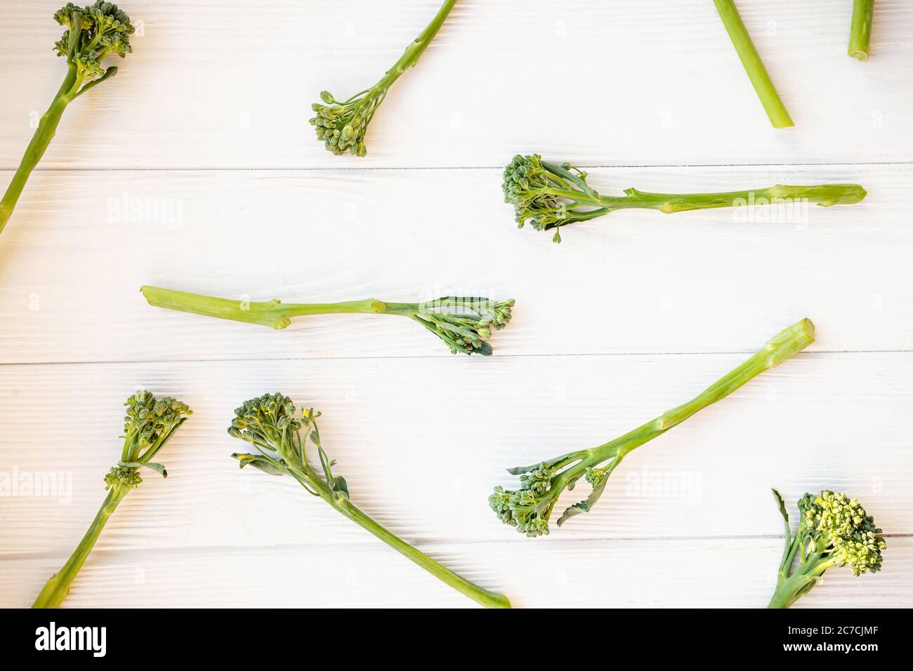 Broccolini crudi su tavola bianca. Foto Stock