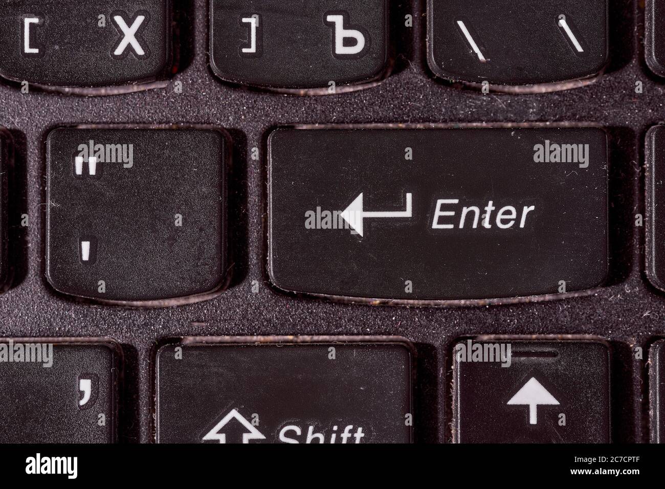 Una tastiera del computer. Mettere a fuoco il pulsante invio. Sfondo nero Foto Stock