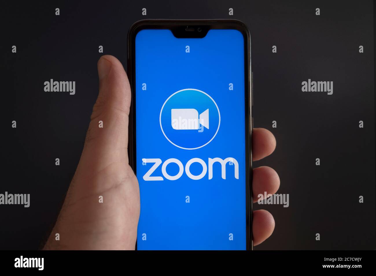 Lo schermo di uno smartphone con il logo dell'app Zoom cloud meeting video conference su sfondo nero Foto Stock