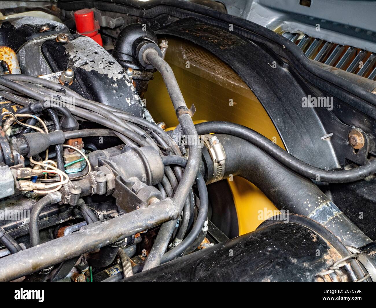 Parte anteriore del vano motore di una vettura classica Jaguar XJ6 Serie III a sei cilindri 1985, con cofano sollevato e ventola di raffreddamento del motore e del radiatore in funzione. Foto Stock