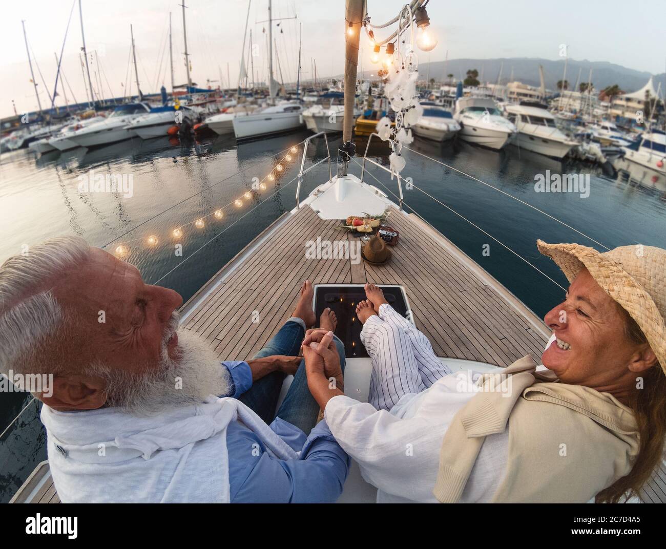 Coppia senior in vacanza in barca - persone anziane felici che si divertono a celebrare l'anniversario di matrimonio in viaggio in barca Foto Stock