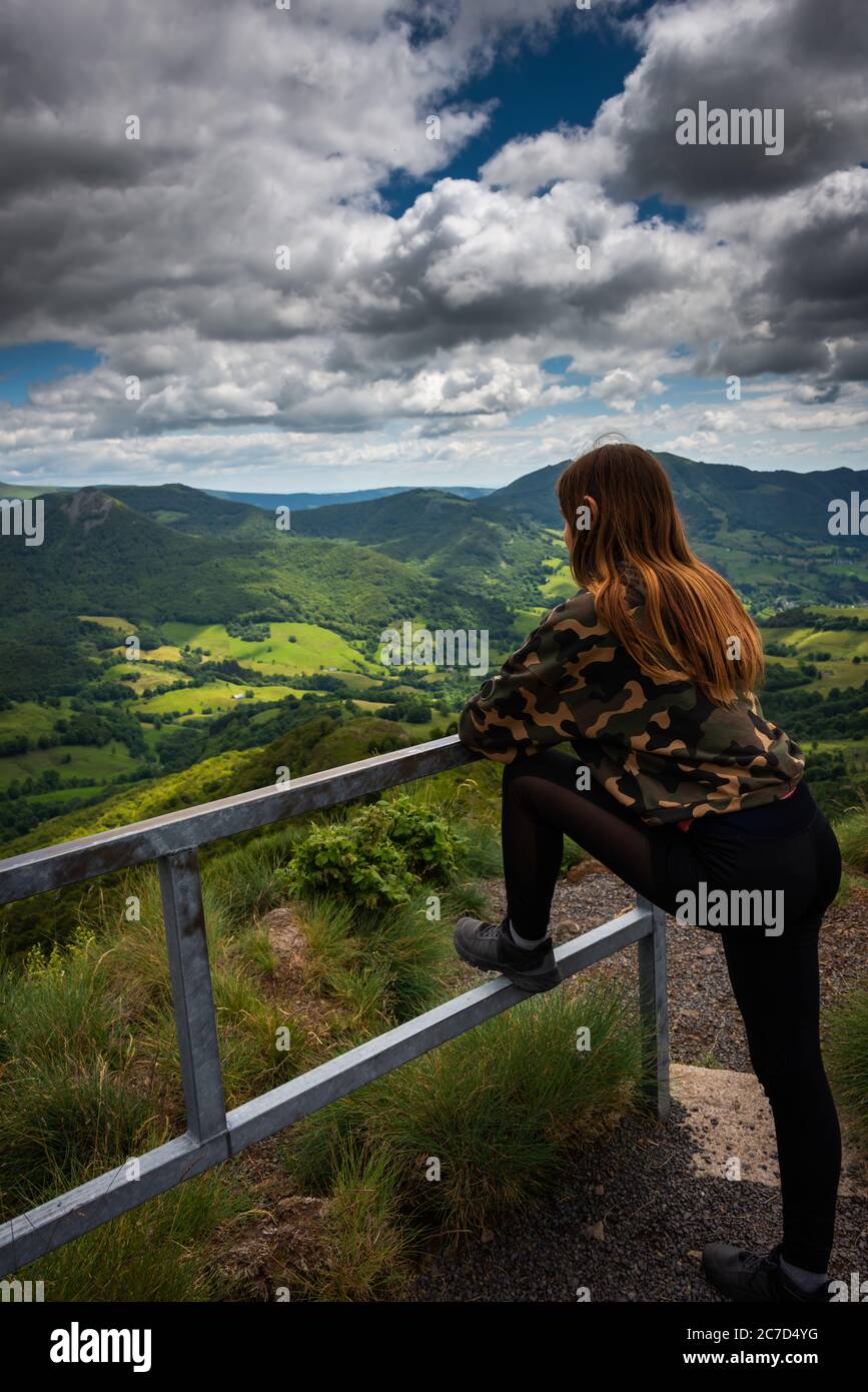 Giovane donna che si allunga guardando la vista dei vecchi vulcani, vacanze avventura, auvergne ,Francia . Foto Stock
