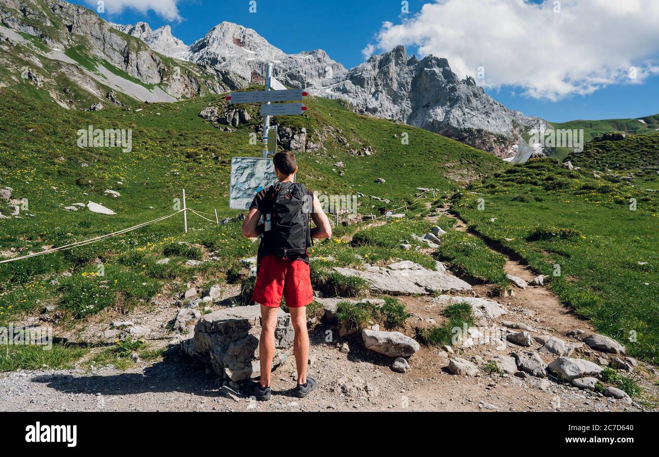 Escursione in montagna viaggio in Europa. Escursionista con zaino in montagna controlla mappa in montagna paesaggio sfondo. Banner panoramico di escursionista su avventura Foto Stock