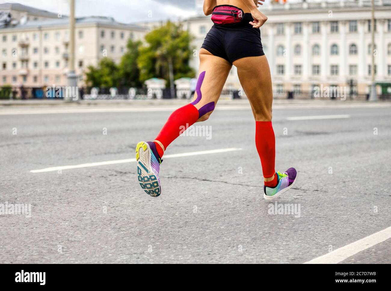 ragazza runner in calze di compressione correre in maratona pioggia sulla  strada della città Foto stock - Alamy