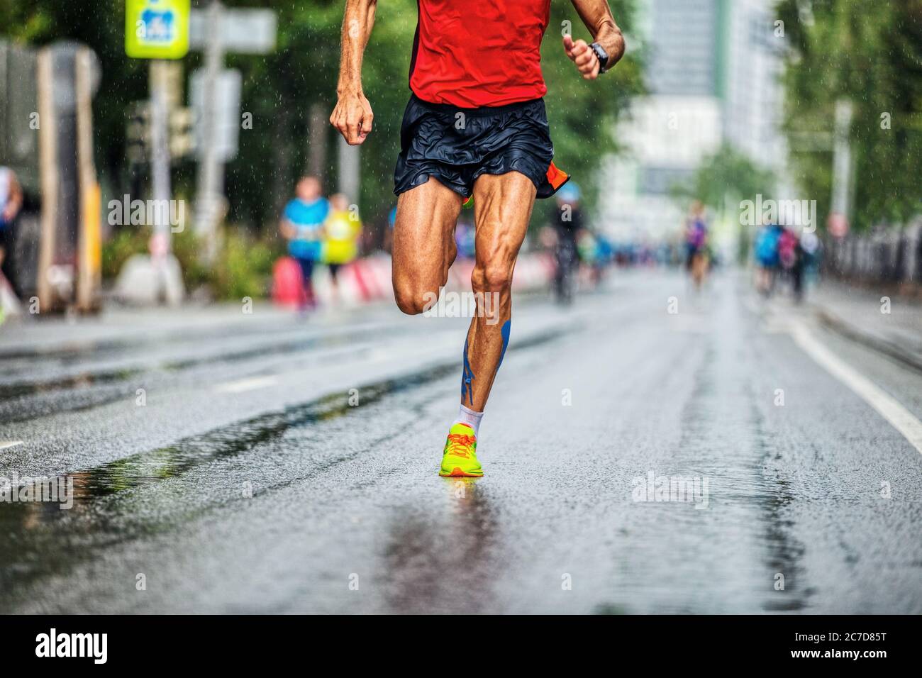 l'atleta perfetto delle gambe corre in maratona con il tempo delle piogge Foto Stock