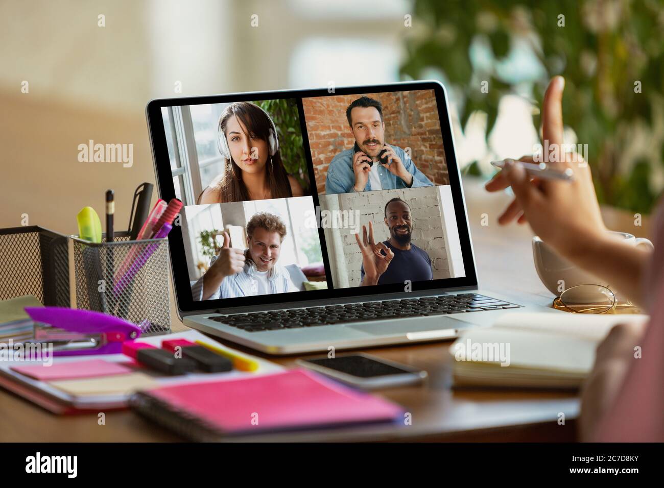 Riunione remota. Donna che lavora da casa durante il coronavirus o COVID-19 quarantena, concetto di ufficio remoto. Giovane capo, manager davanti al monitor durante una conferenza online con colleghi e team. Foto Stock