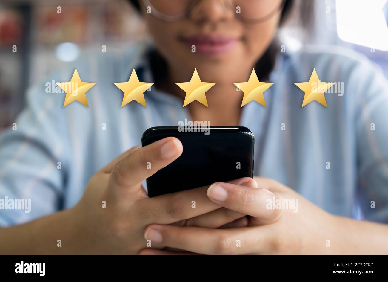 Cliente femminile che lascia il feedback sulla soddisfazione aziendale tramite telefono cellulare dopo l'esperienza commerciale Foto Stock