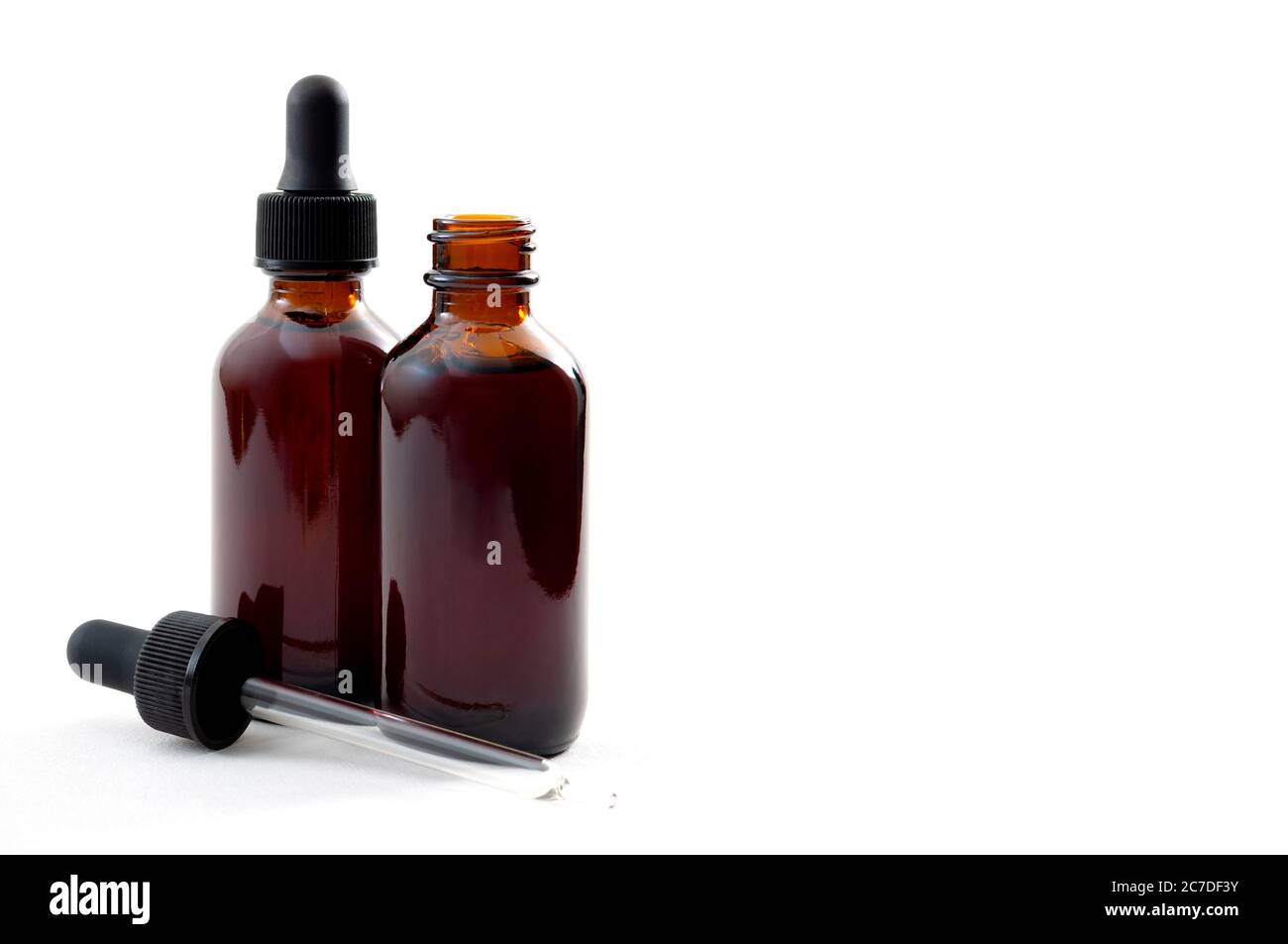 Concetto di farmaci omeopatici per la cura e la tintura liquida con primo piano su due flaconi di vetro marrone, uno aperto e uno chiuso con contagocce isola Foto Stock Concetto di farmaci omeopatici per la cura e la tintura liquida con primo piano su due flaconi di vetro marrone, uno aperto e uno chiuso con contagocce isola Foto Stock