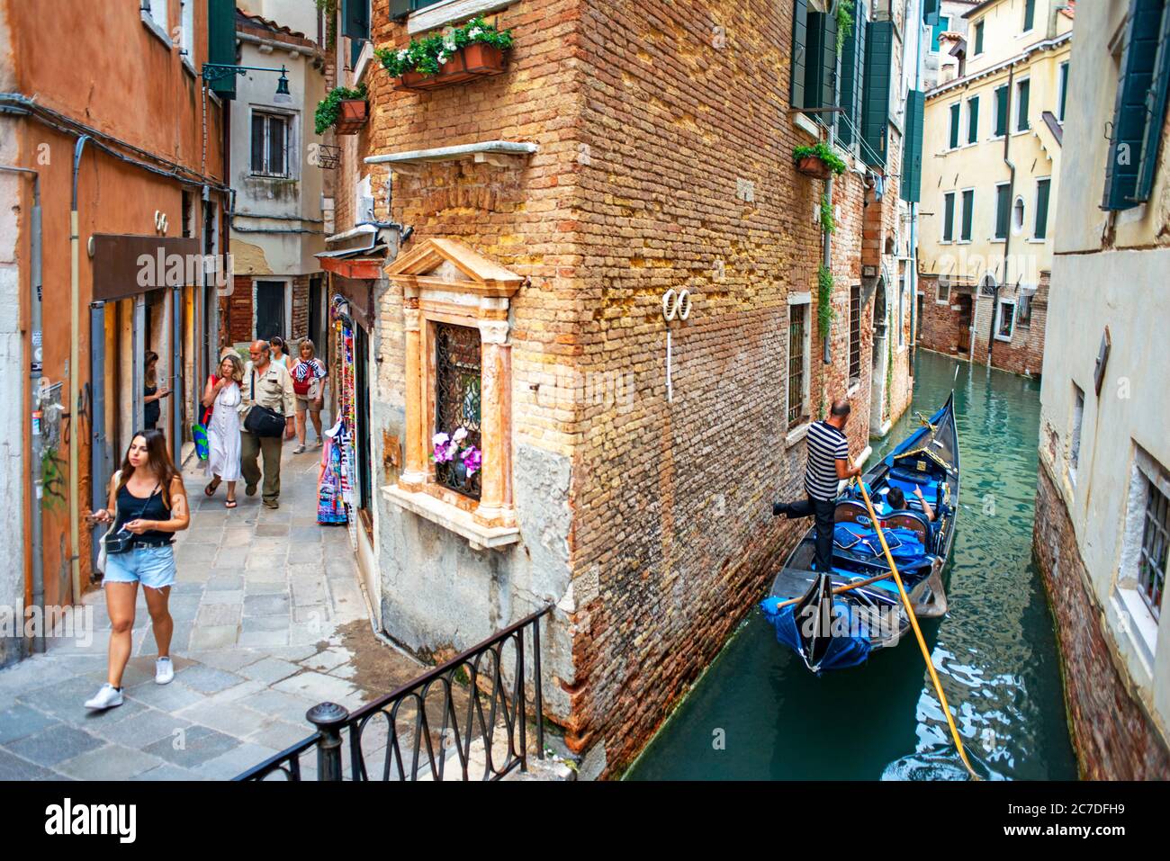 Fondamenta de l'Osmarin, San Marco, Venezia, Italia lungo un canale con gondole e gondoliere in piccoli canali. Gondole, con turisti, vicino al Gra Foto Stock