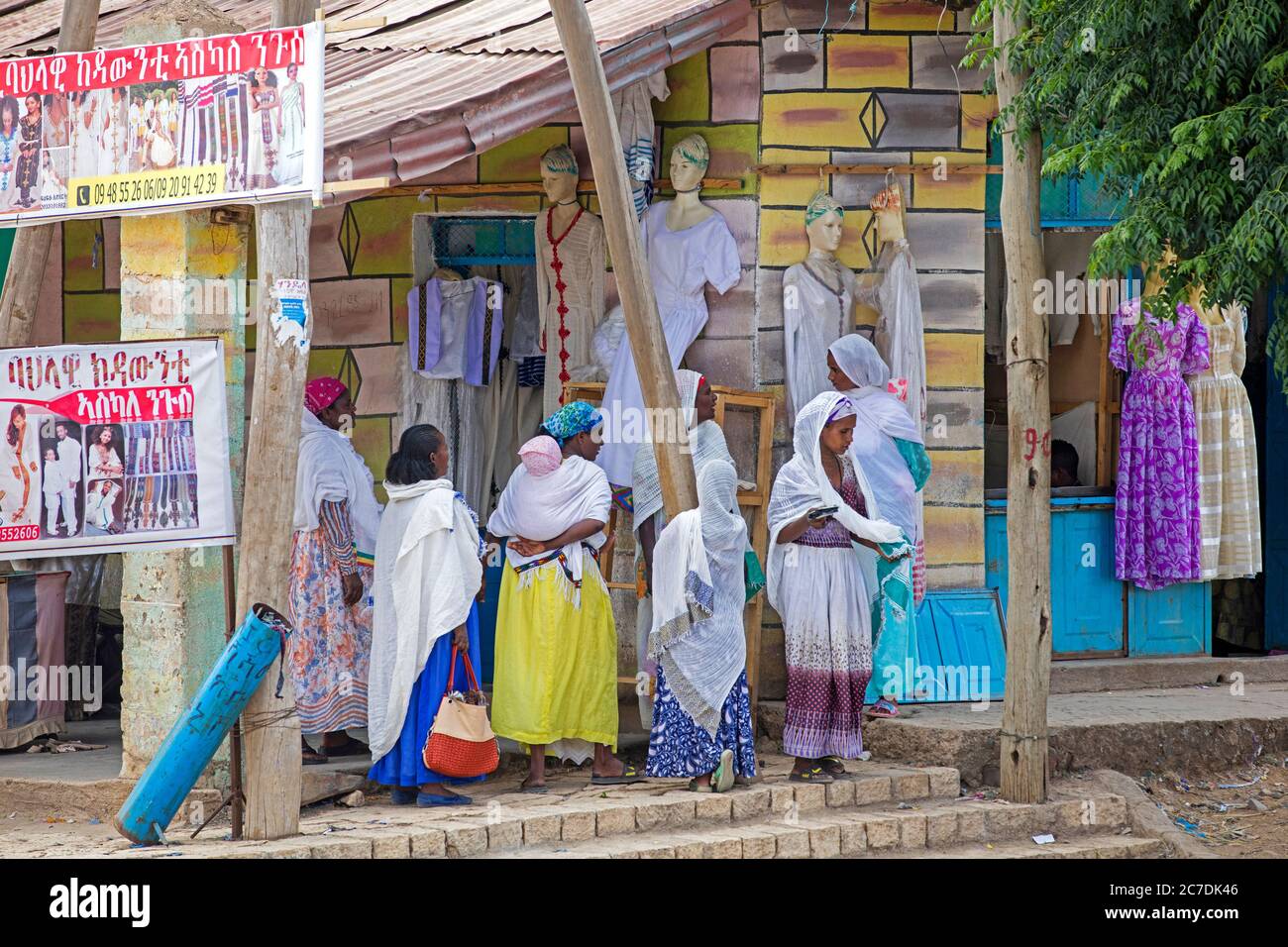 Donne nere locali in via di shopping di fronte ai negozi di abbigliamento nella città Axum / Aksum, Maekelay zona, Tigray Regione, Etiopia, Africa Foto Stock