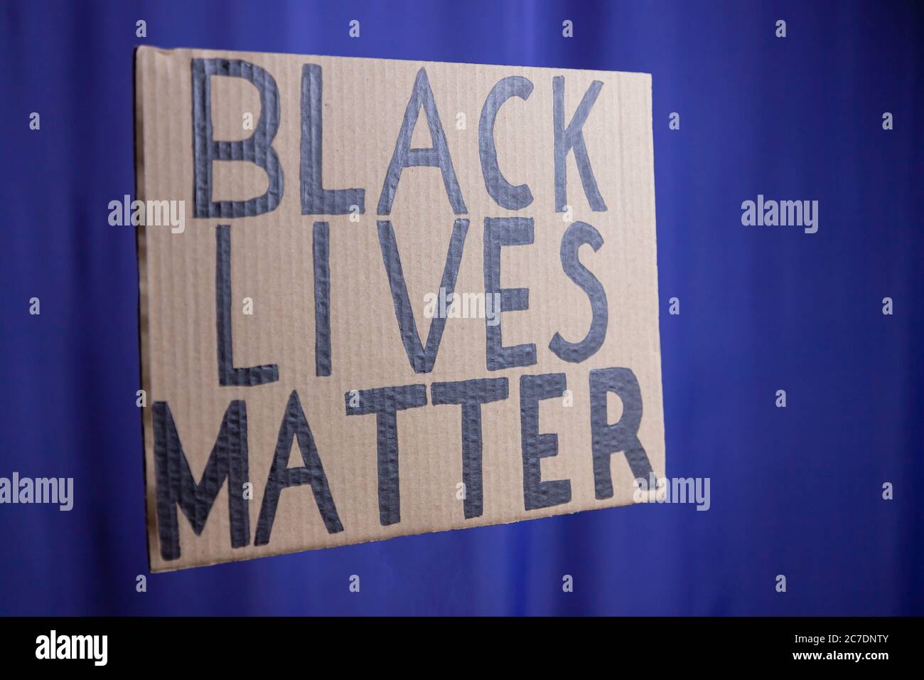 LA VITA NERA È IMPORTANTE su uno sfondo blu sfocato. Nessun concetto di razzismo. Banner di cartone con il testo 'Black Lives Matter'. Concetto della lotta per gli inor Foto Stock