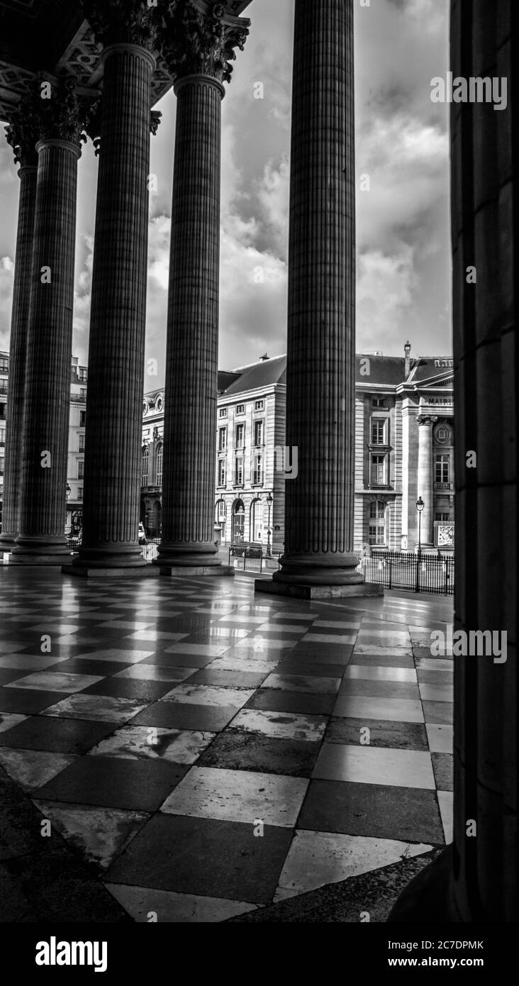 Immagine verticale in scala di grigi di colonne vicino al Pantheon di Parigi sotto un cielo nuvoloso Foto Stock