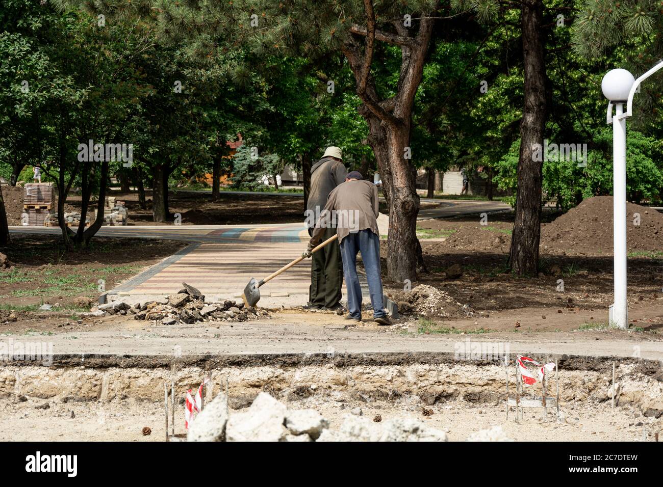 Moldavia, Tiraspol, 25 maggio 2020: I lavoratori posano lastre di pavimentazione in un parco Foto Stock