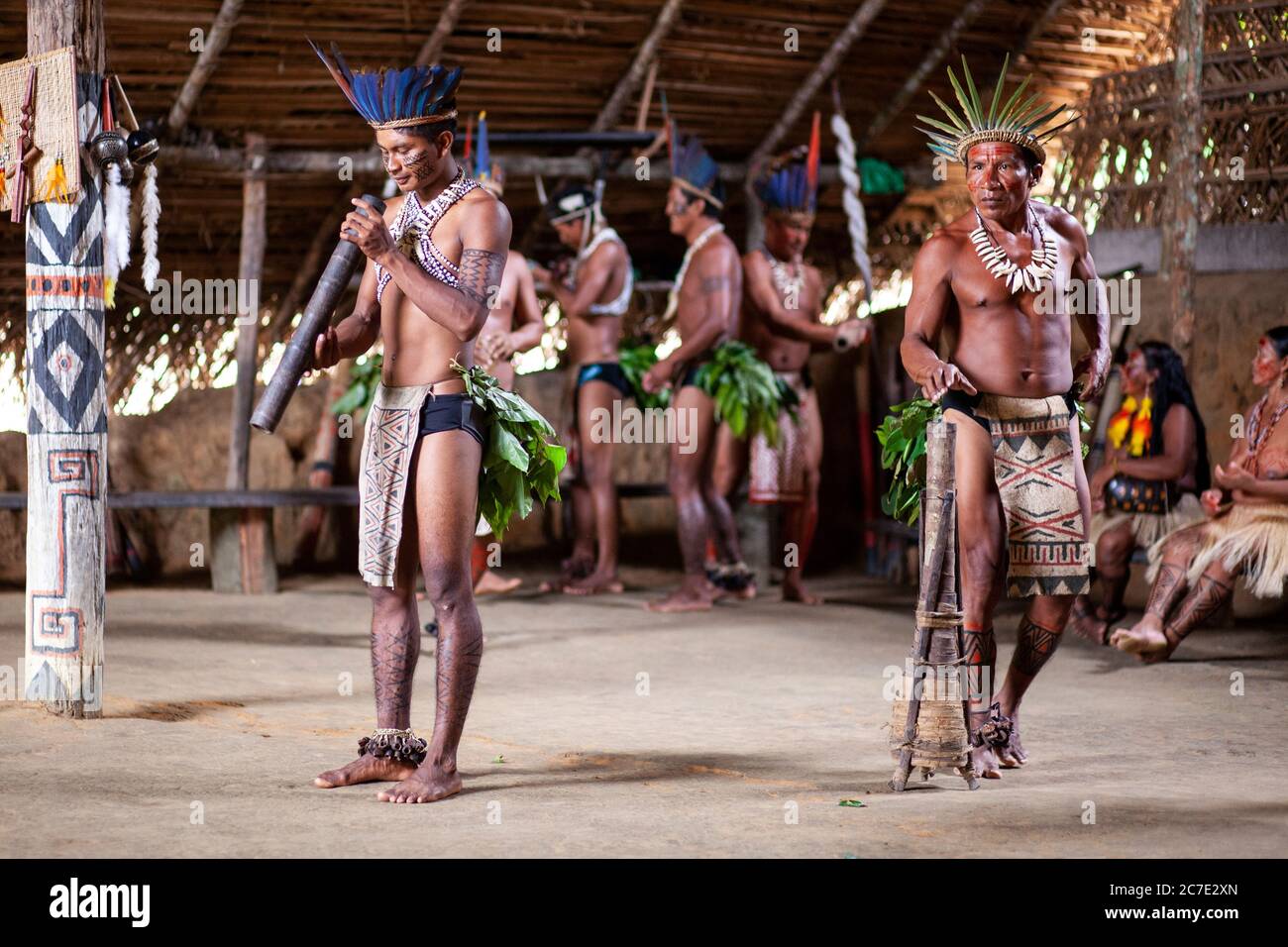 Uomini indigeni che soffiano su uno strumento tradizionale Foto Stock