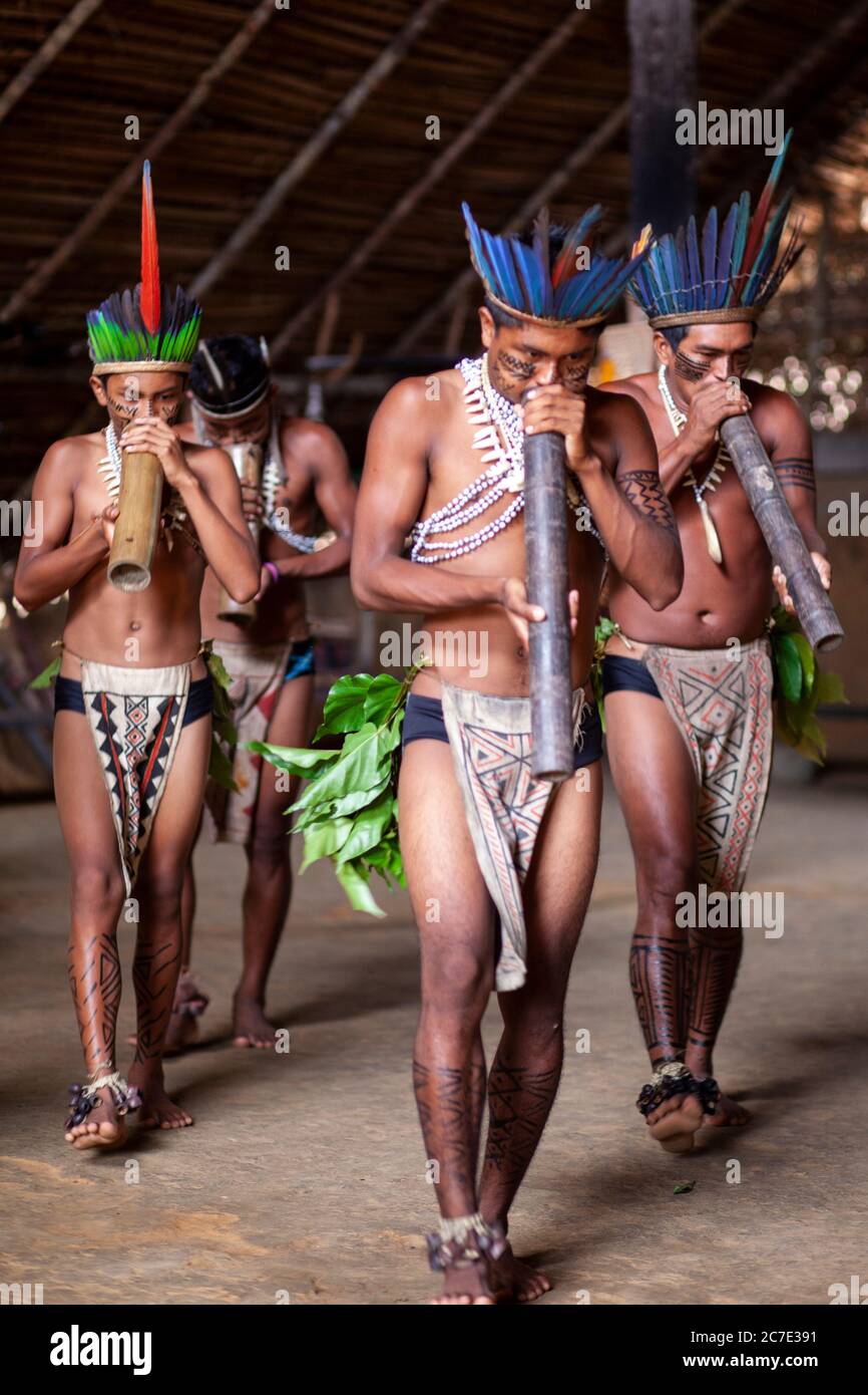 Uomini indigeni che soffiano su uno strumento tradizionale Foto Stock