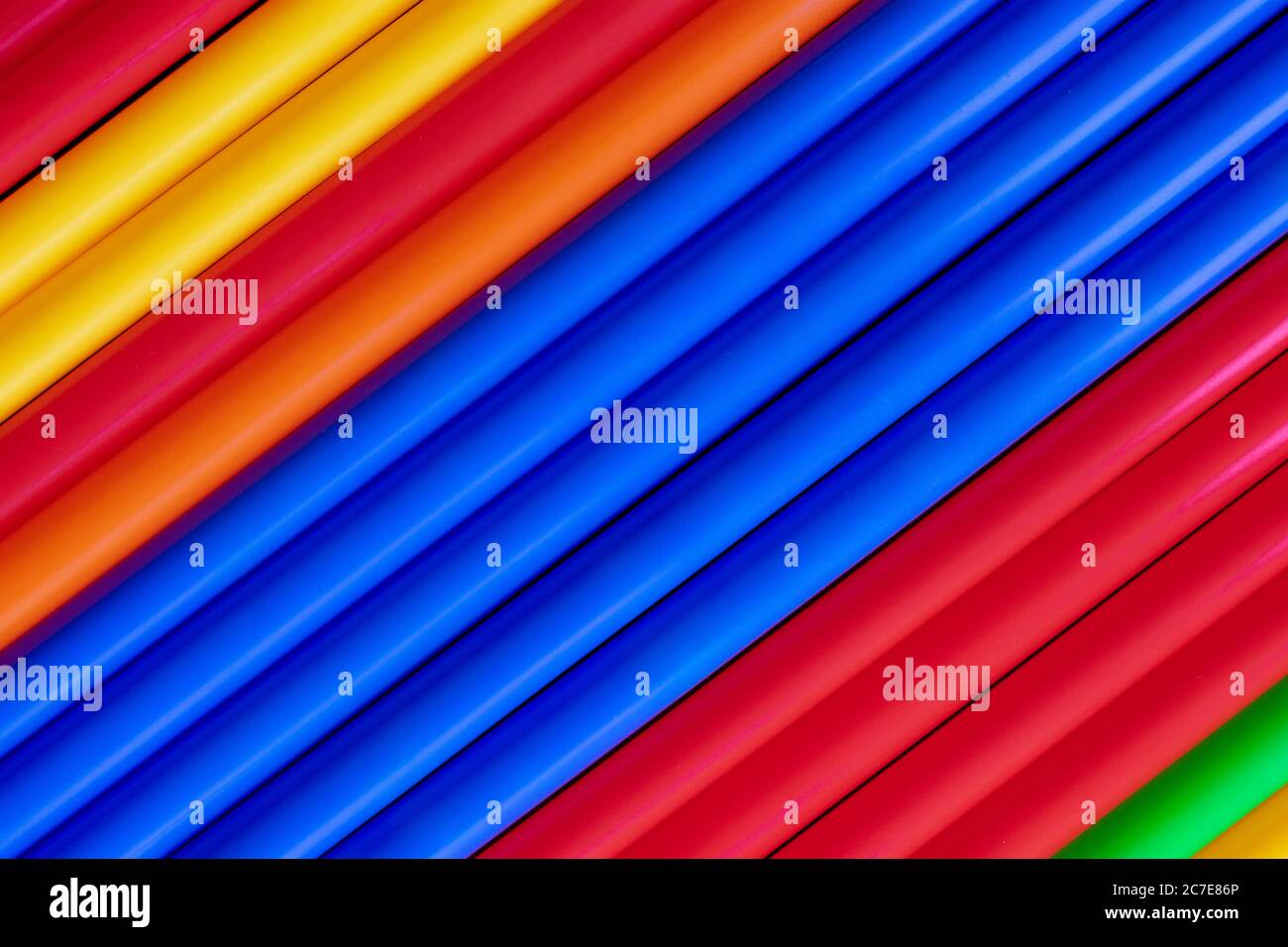 Tubi colorati in plastica si stagliano sullo sfondo diagonale Foto Stock
