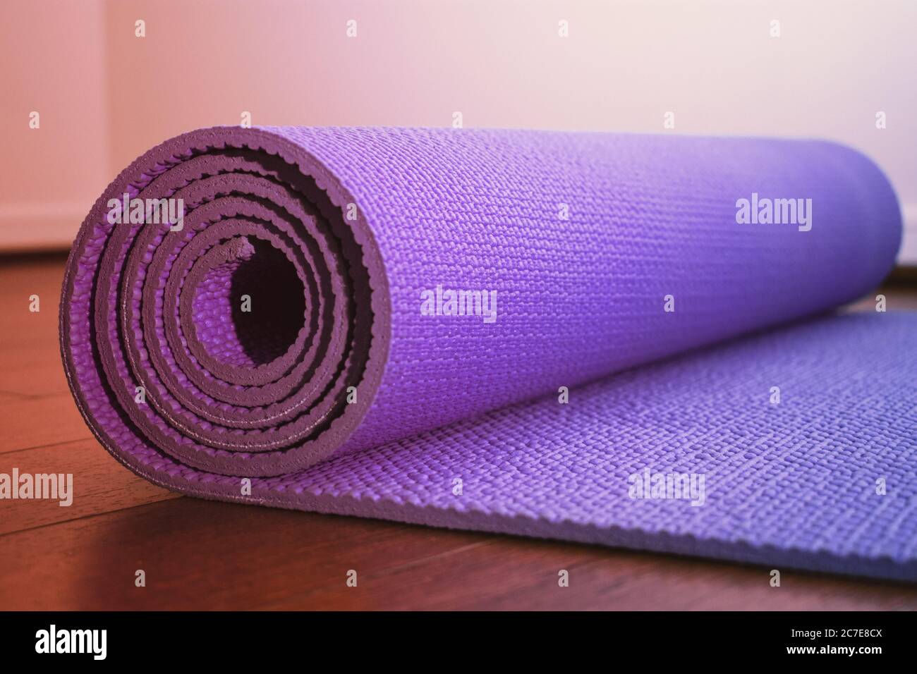 Tappetino yoga viola con morbido effetto pastello sul pavimento della palestra Foto Stock