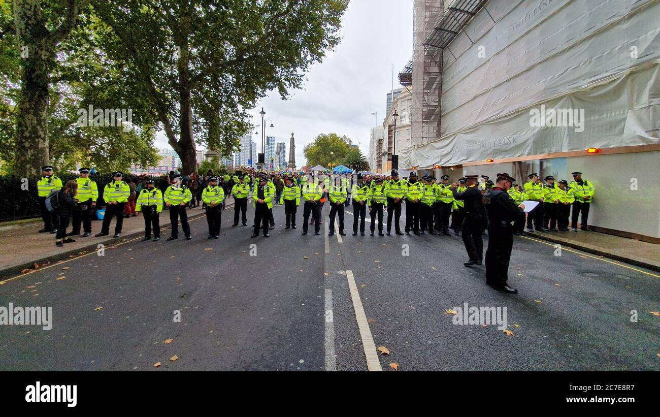 File di polizia si sono schierate sulla via centrale di Londra, preparandosi al controllo della folla durante la protesta di ribellione per l'estinzione Foto Stock