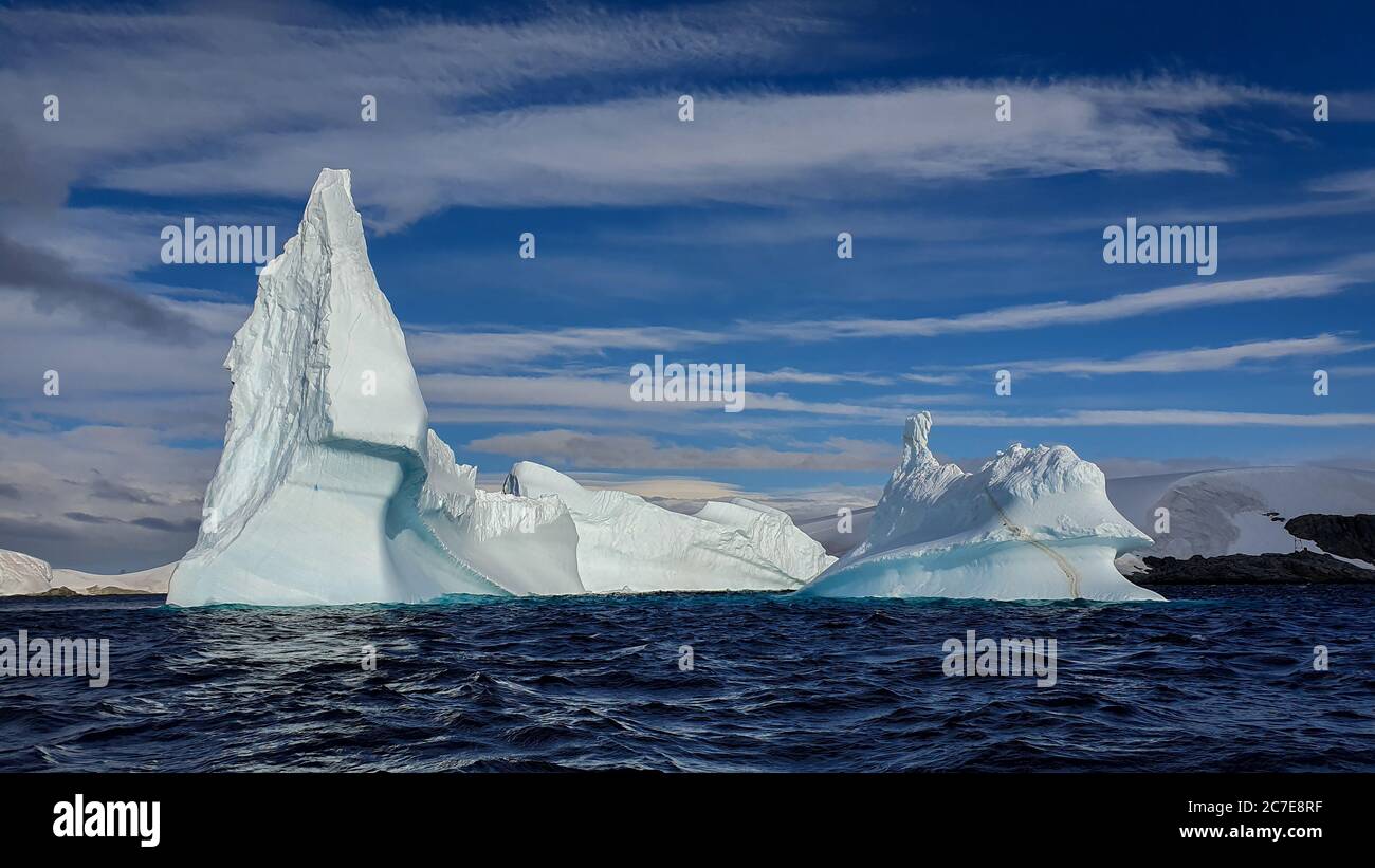 Iceberg sotto il cielo blu con le nuvole in Antartide Foto Stock