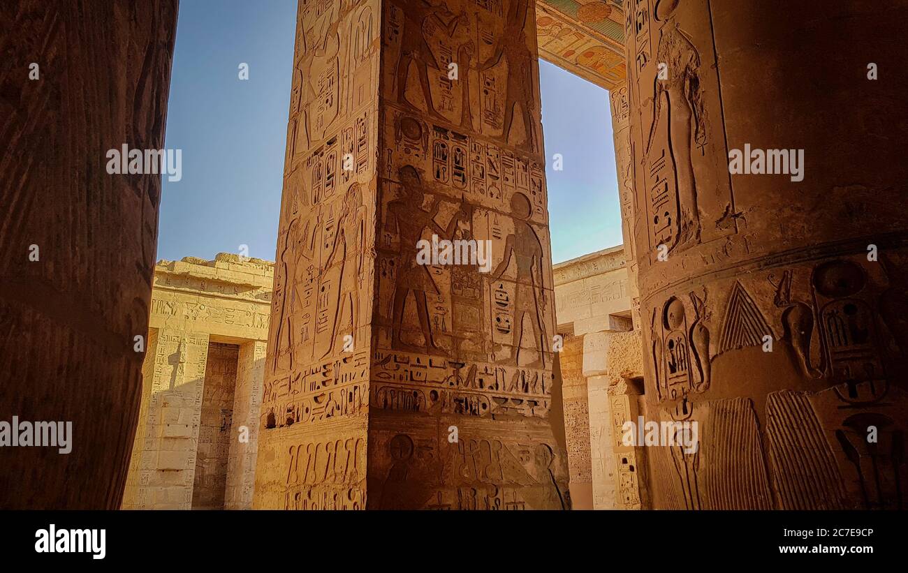 Geroglifici colorati e arte su pilastri nel tempio di Medinet Habu in Egitto Foto Stock