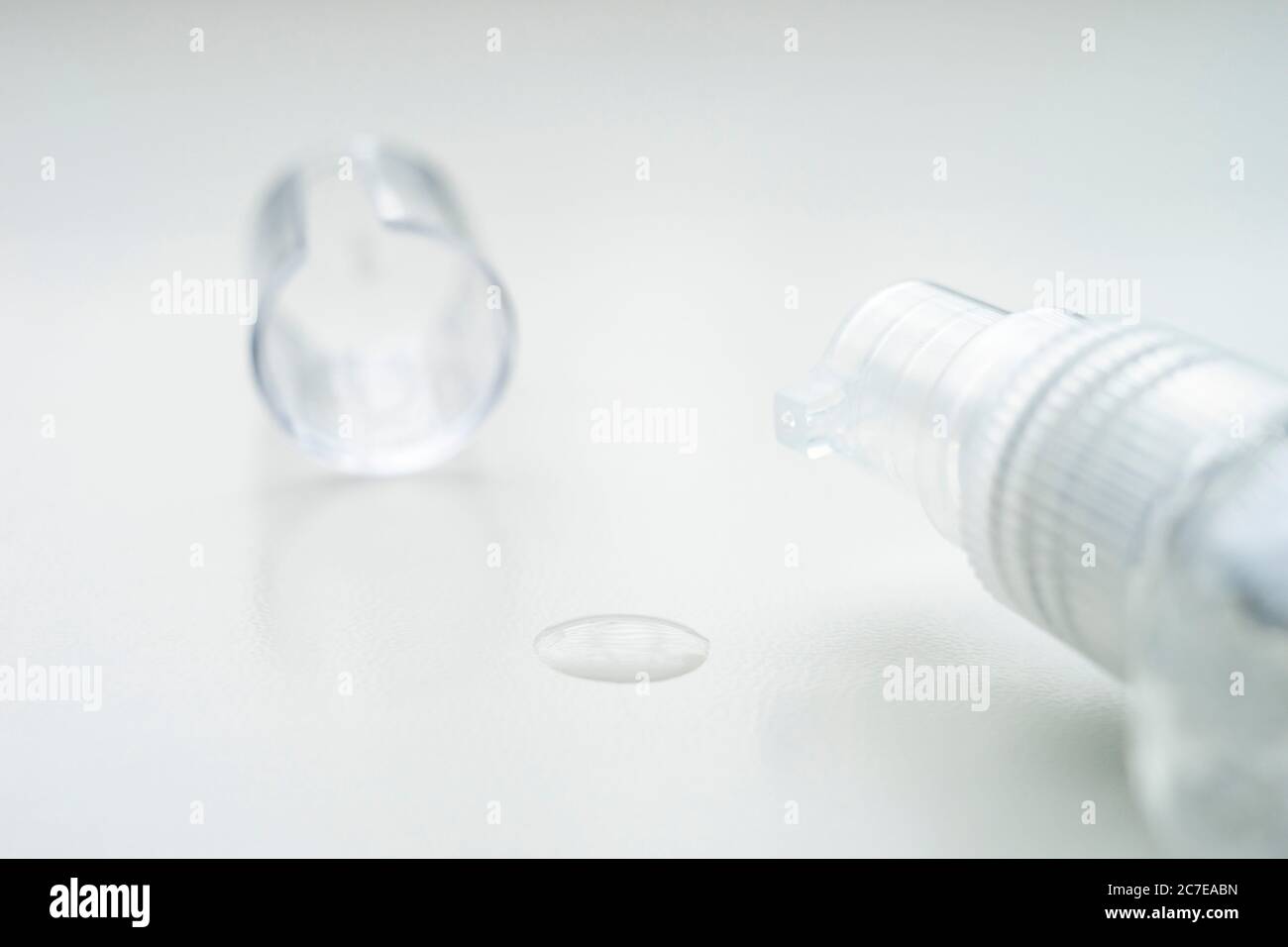 gel igienizzante in un piccolo flacone di plastica con goccia e un tappo sul tavolo bianco. Foto Stock