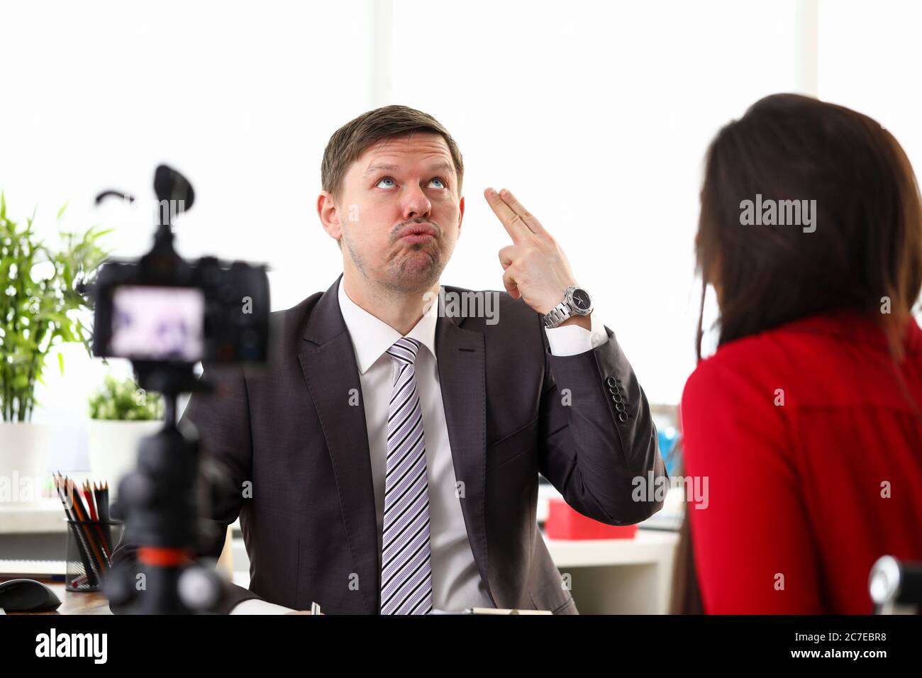 Donna in rosso intervistando dipendente Foto Stock