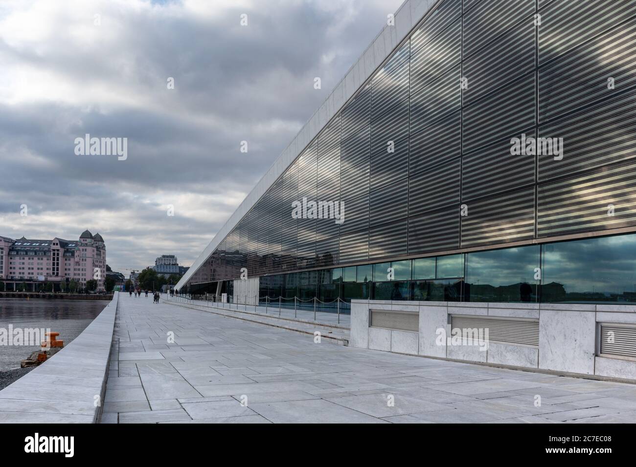 Teatro dell'Opera di Oslo in Norvegia. Esterno dall'architettura moderna dell'edificio con granito bianco e bei riflessi di vetro con nuvole panoramiche. Foto Stock