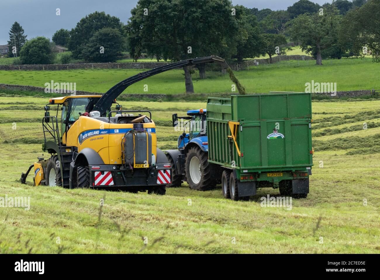 Veicoli agricoli che raccolgono insilato in una fattoria dello Yorkshire in Inghilterra, Regno Unito Foto Stock