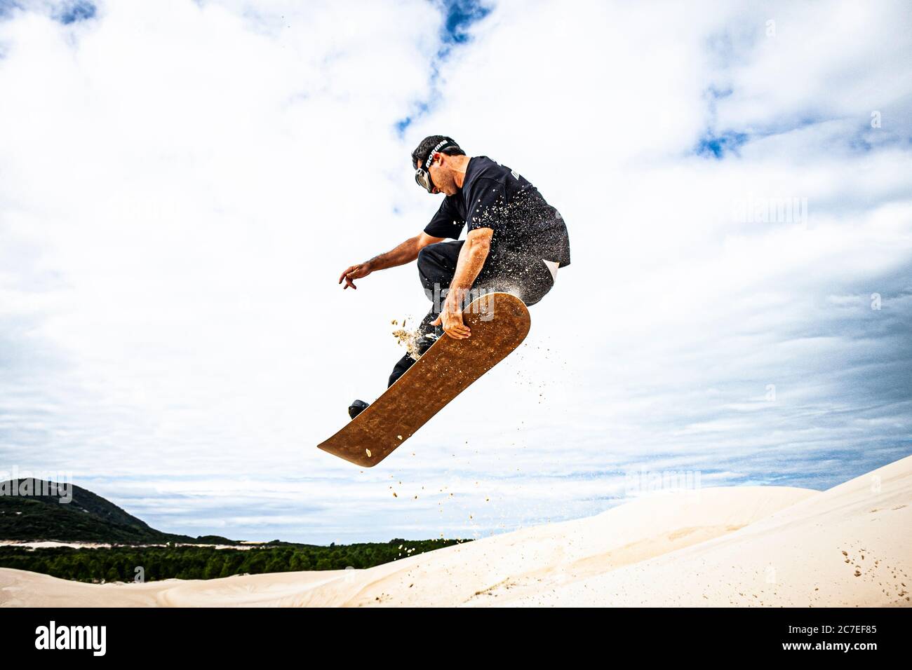 Sandboarding uomo sulle dune del Rio Vermelho state Park. Florianopolis, Santa Catarina, Brasile. Foto Stock