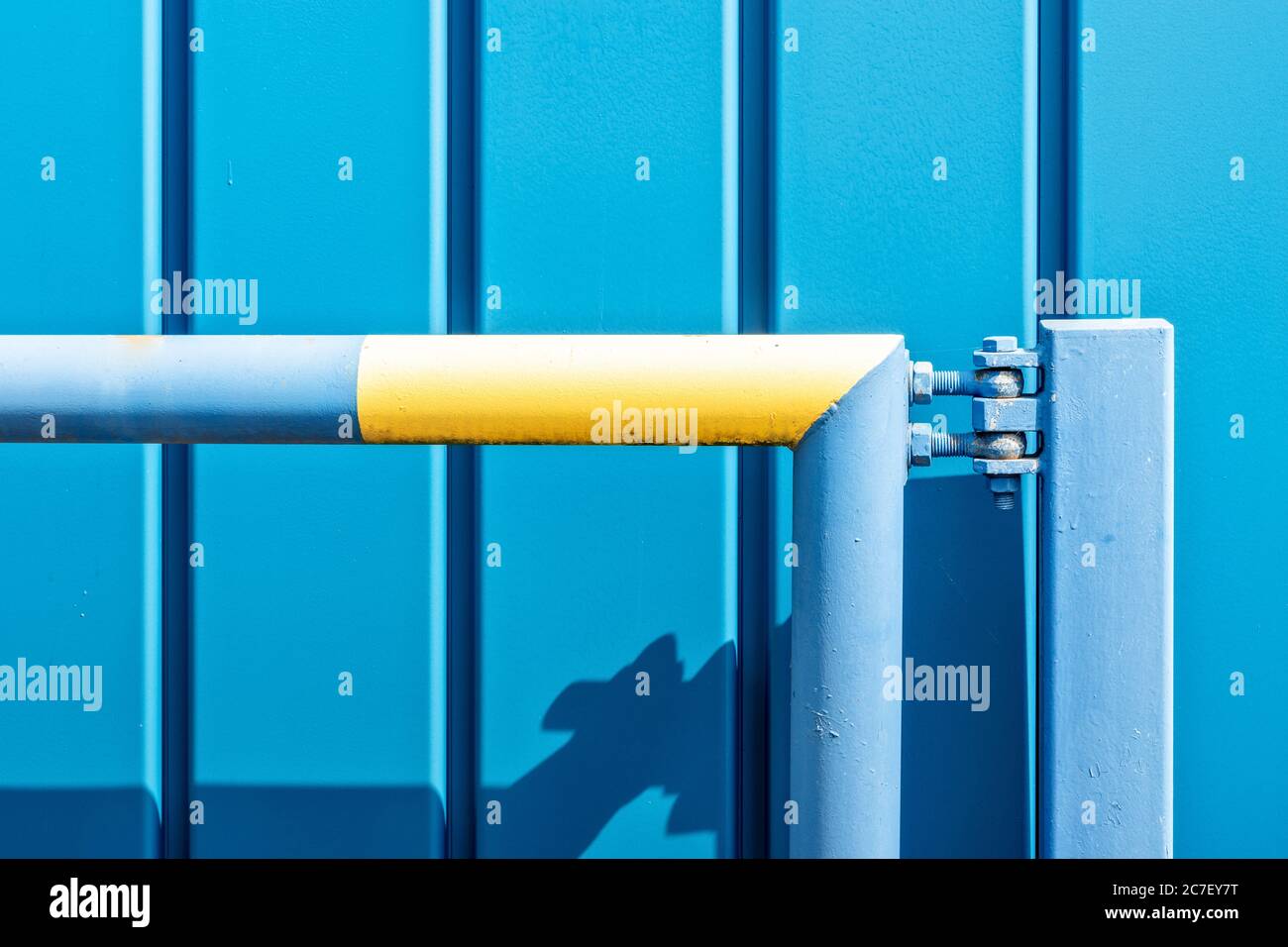 Immagine orizzontale di una parete blu di metallo con un blu e tubo giallo - perfetto per uno sfondo splendido Foto Stock