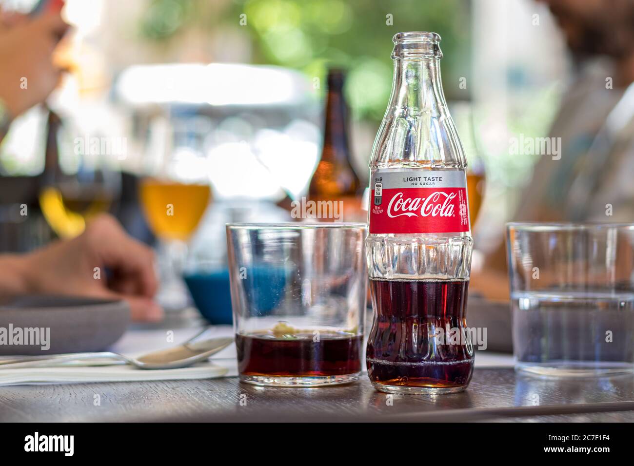 Una bottiglia di vetro di Coca Cola leggero gusto su un tavolo all'aperto. Foto Stock