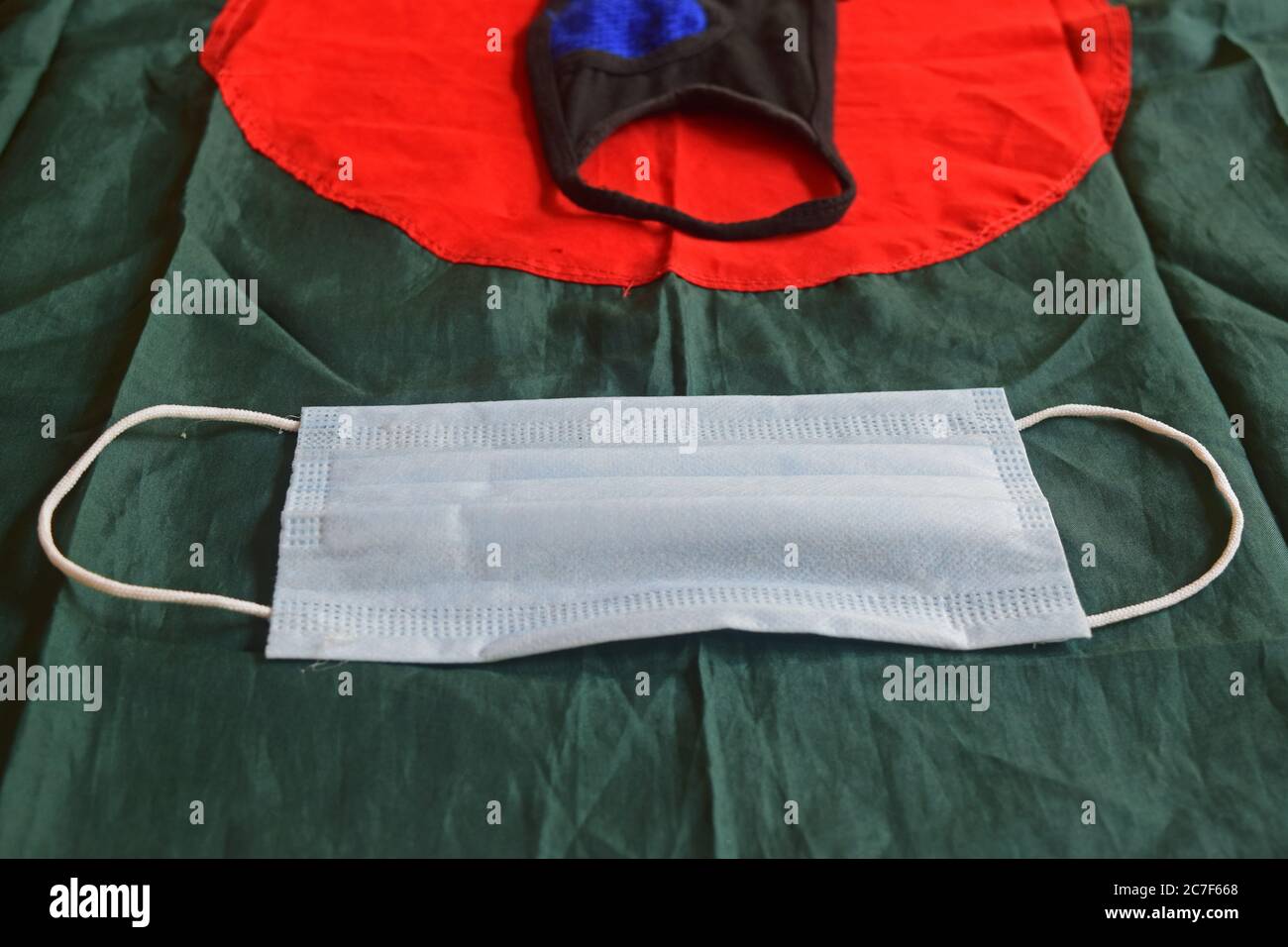 Maschera chirurgica davanti alla bandiera nazionale del Bangladesh Foto Stock