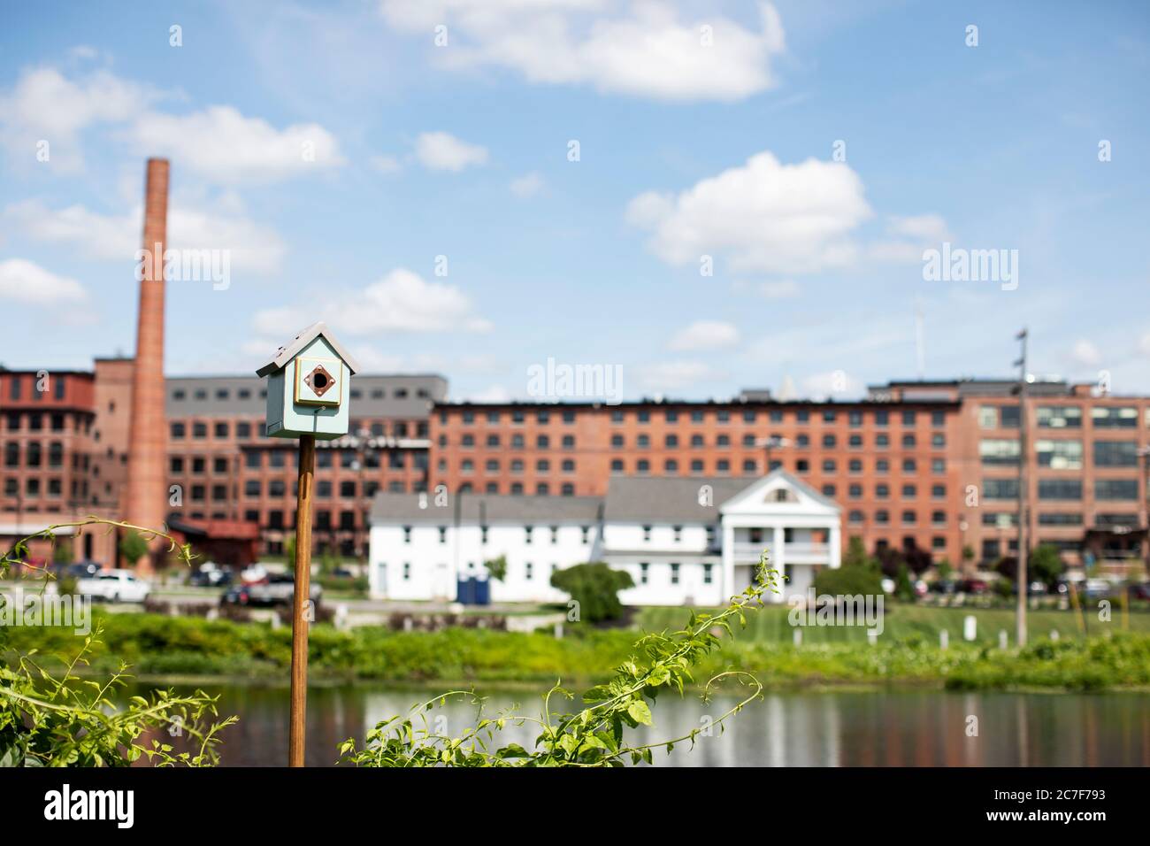 Una casa degli uccelli presso Water Street e il parco francese rinascimentale con ex mulini tessili lungo il fiume Nashua a Nashua, New Hampshire, Stati Uniti. Foto Stock