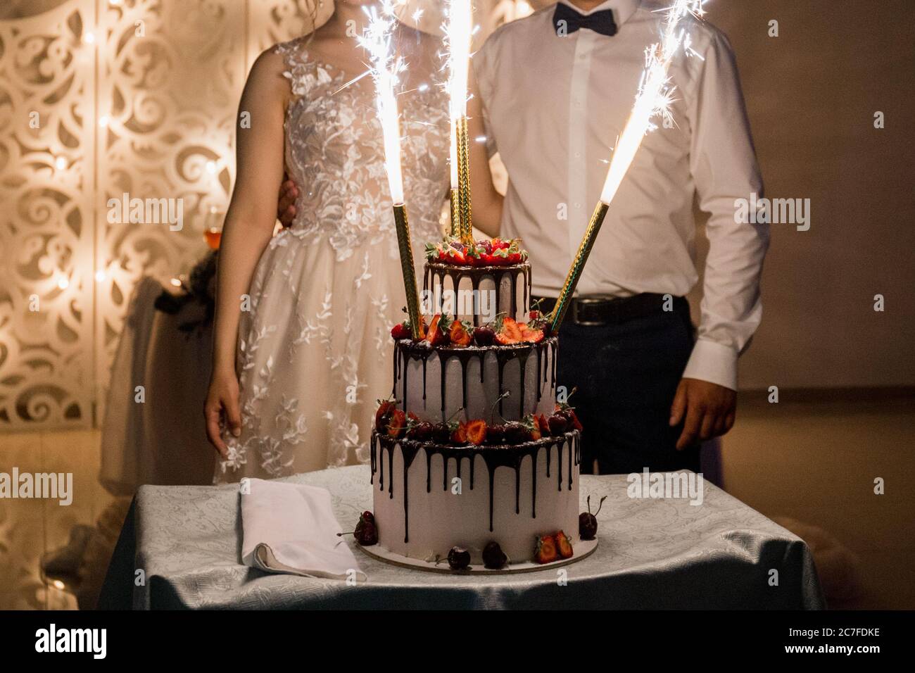 lo sposo e la sposa tagliano la torta di nozze Foto Stock