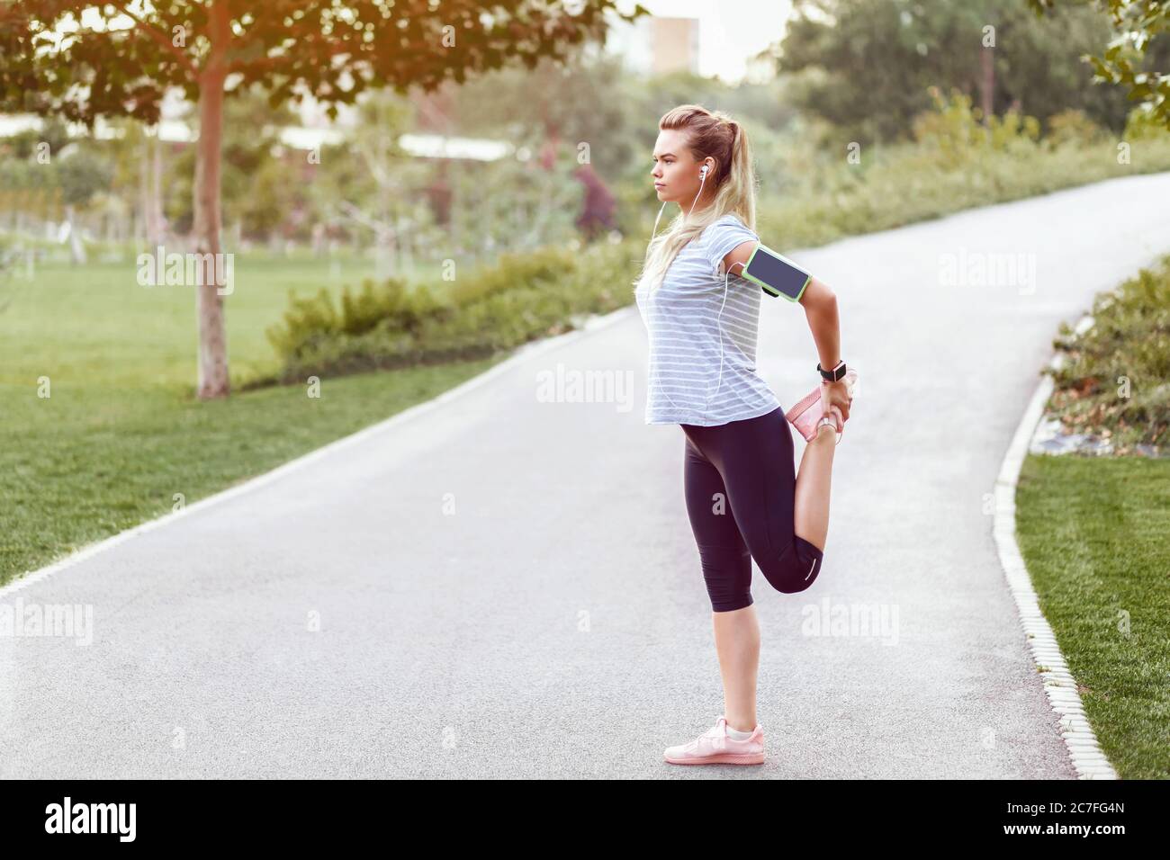 Donna sportiva che fa jogging in un parco vuoto a causa di misure di distanza sociale Foto Stock